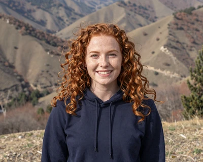 Megan, a 26-year-old redhead in a hoodie at a mountain overlook, a MileDating profile for trucker dating